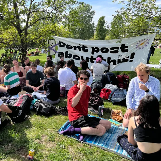 Picknick im Park mit »Don't post about this«-Banner